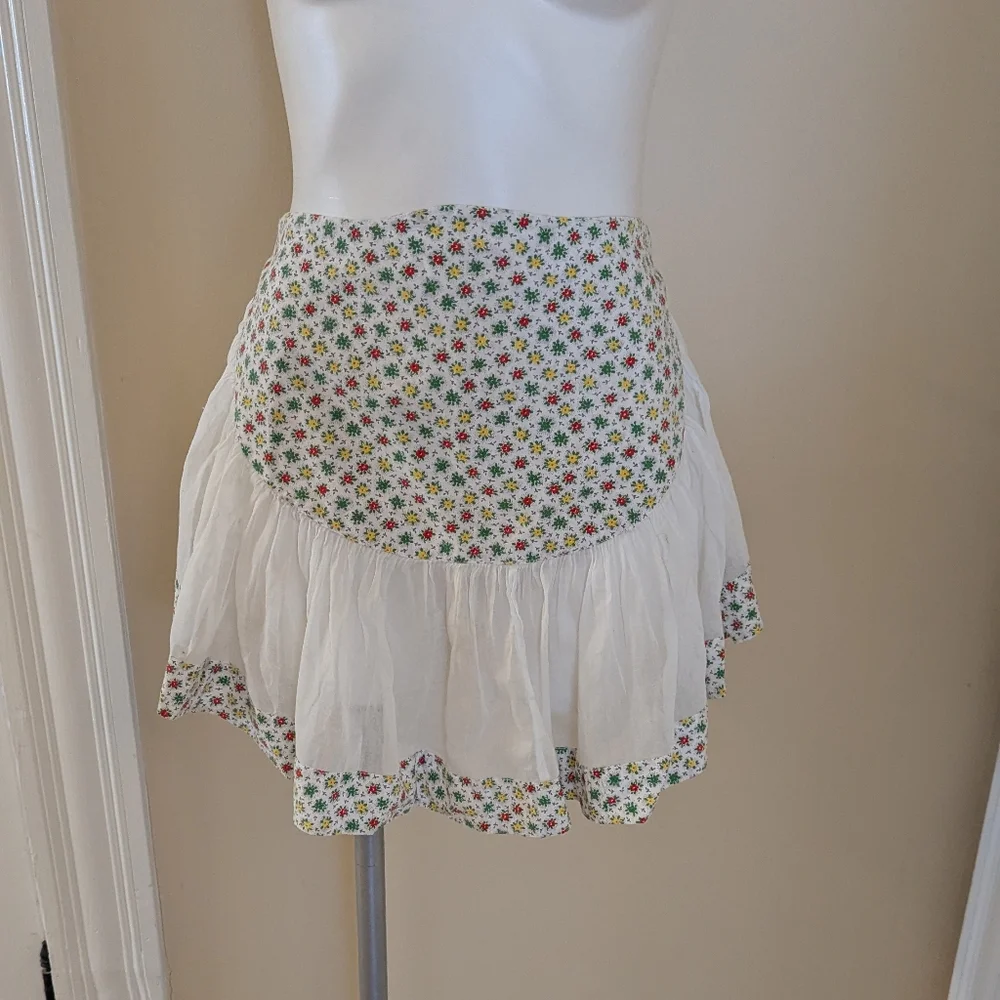 Vintage handmade white apron with red, green and red floral print.